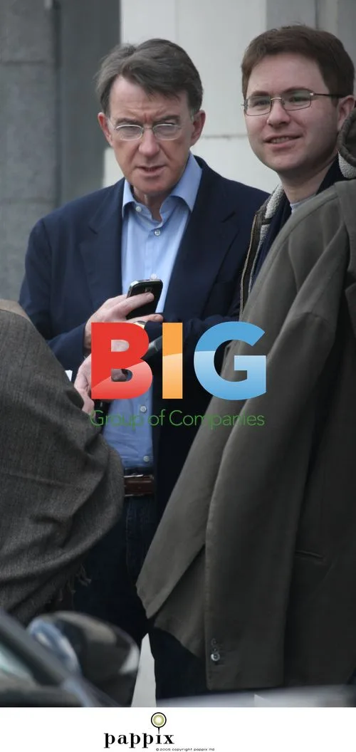 Peter Mandelson checks phone with aide