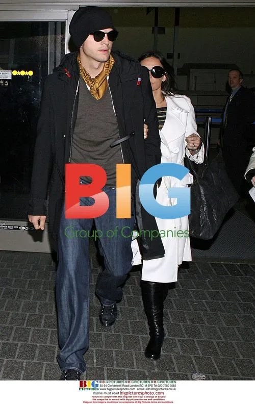 Demi Moore hides behind Ashton Kutcher at LAX