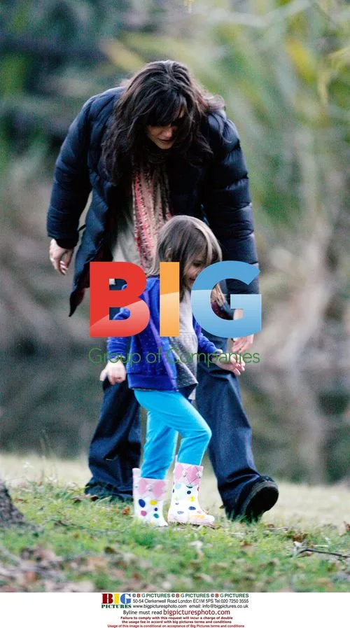 Katie Holmes and Suri playing in leaves on set